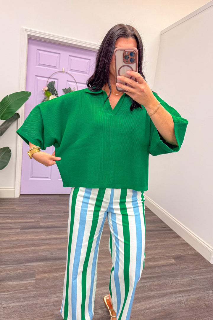 Showing the fit of a green lightweight sweater top
