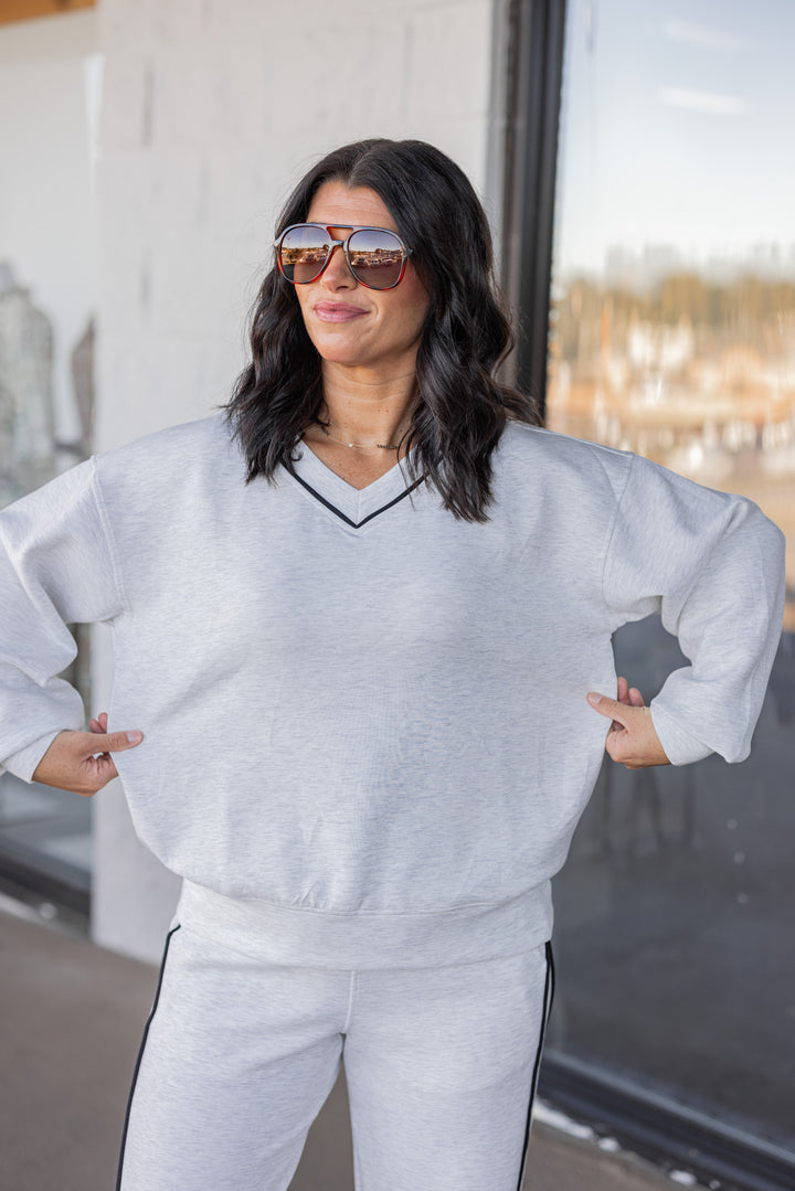 Women's grey and black striped piping scuba knit top by Rae Mode showing true to size fit