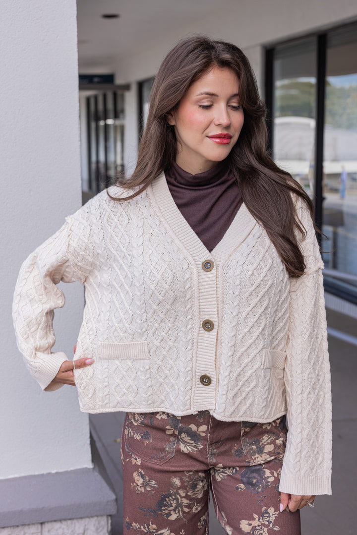 Women's cable knit button front sweater cardigan in ecru with ribbed trim by Entro showing sweater's length