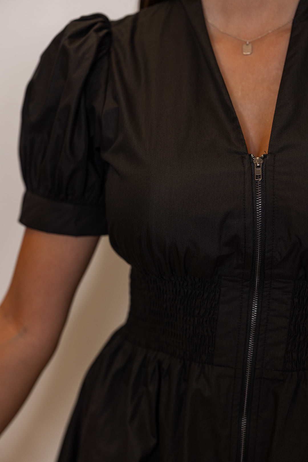 Womens black dress by Entro showing zip front closure