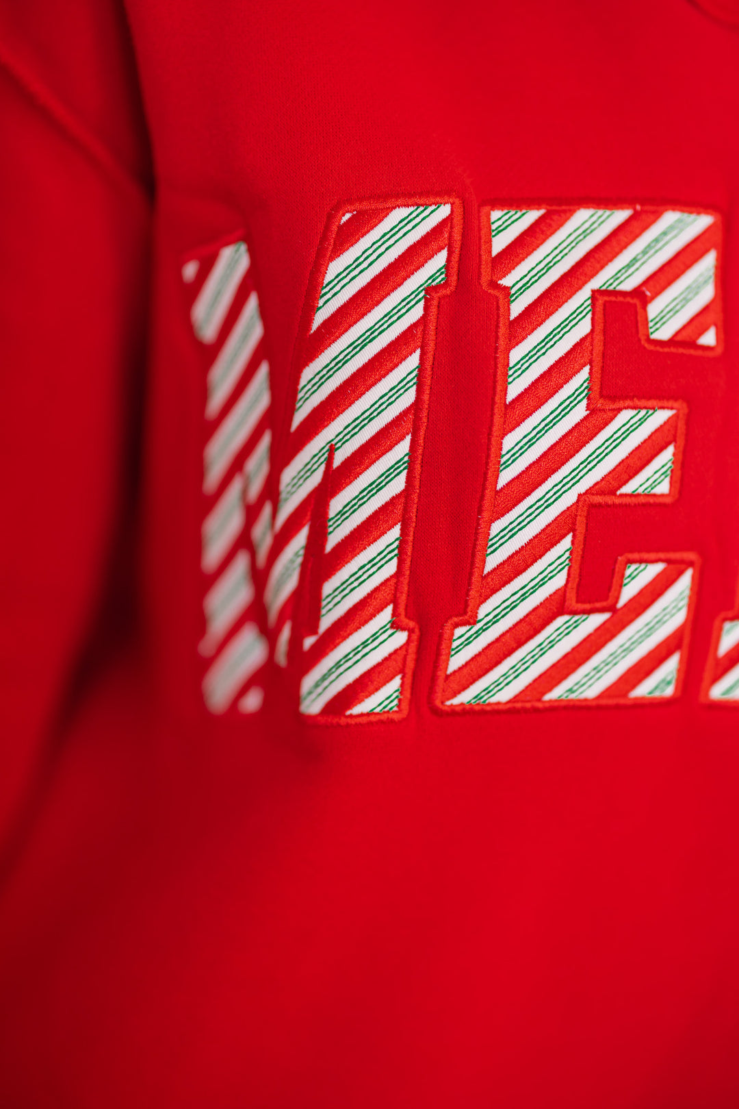 Merry red embroidered Christmas sweatshirt by Bucketlist showing close look at striped pattern on letters