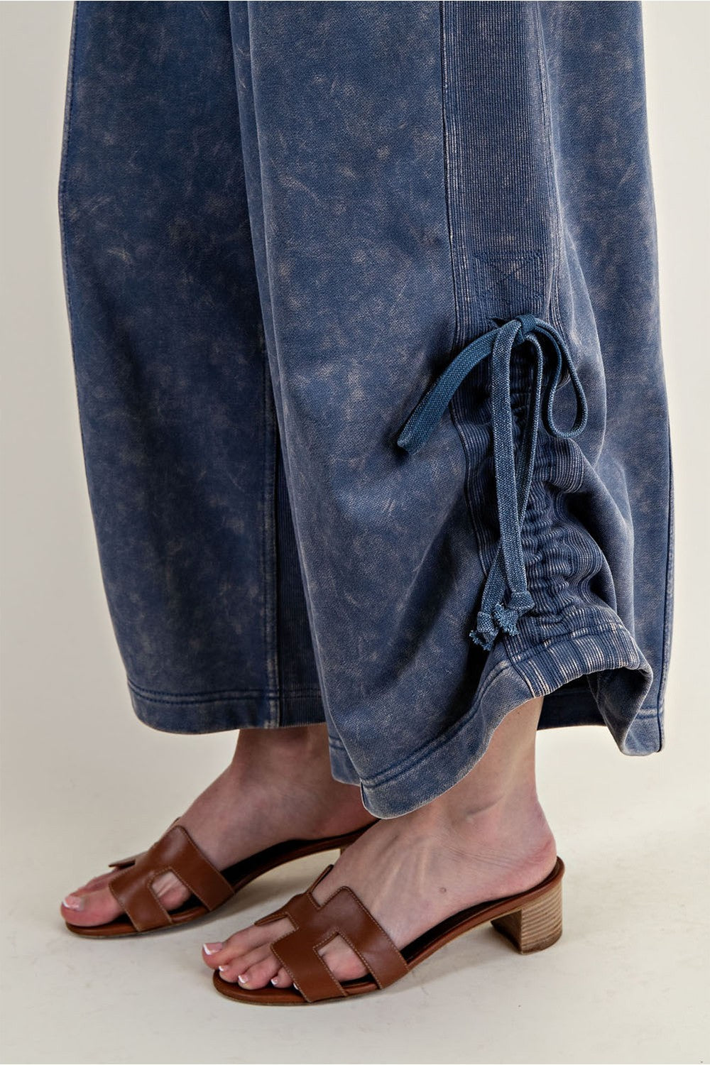 Women's knit jumpsuit in washed blue denim color with adjustable length by ee:some showing drawstring hem