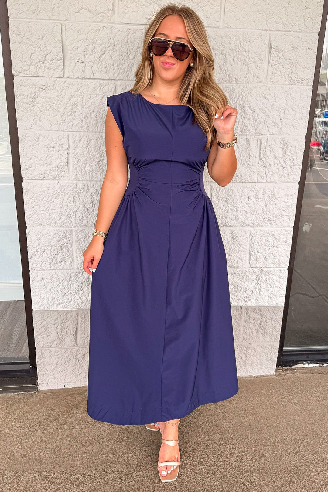 solid navy blue cinched waist sleeveless midi dress with fitted bodice