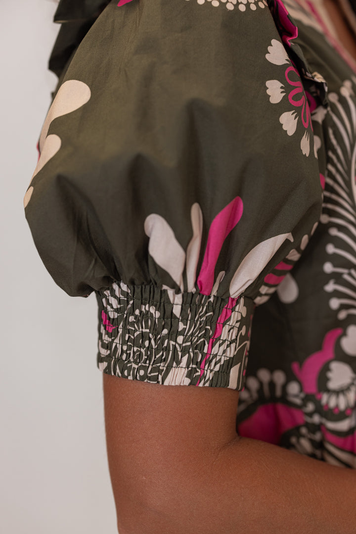 Close-up of a person wearing a patterned outfit with a floral design showing the sleeve