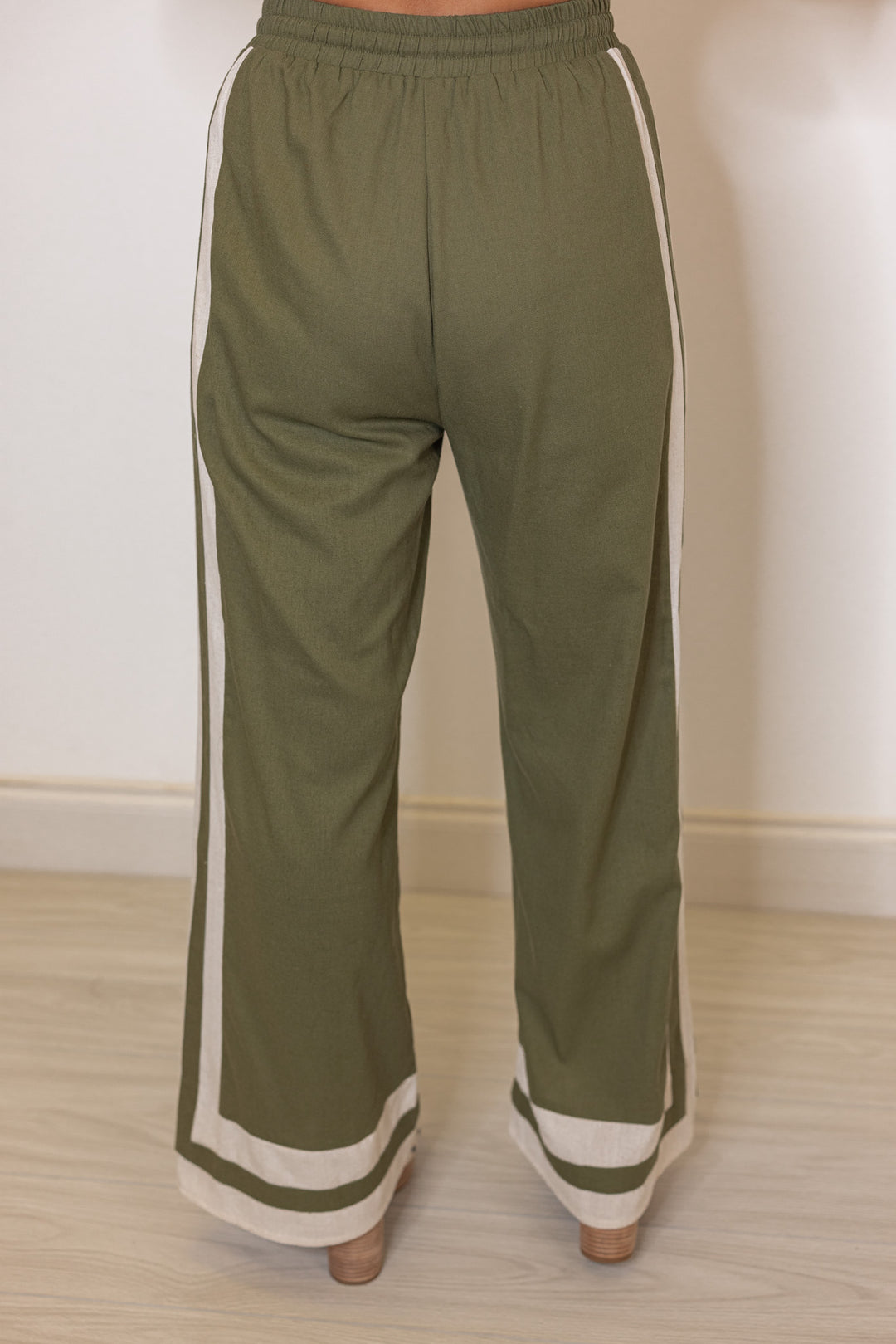 Women's olive green elastic waist linen pants with oatmeal trim throughout by Entro showing back view