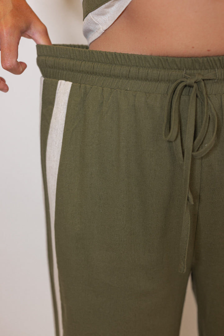 Women's olive green elastic waist linen pants with oatmeal trim throughout by Entro showing elastic waistand