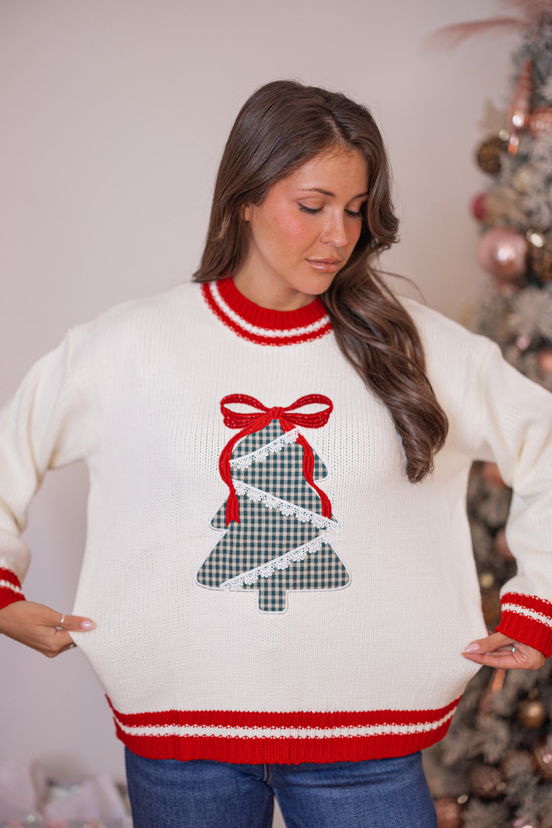 Women's cream sweater with a green plaid Christmas tree and red trim details by Main Strip showing true to size fit