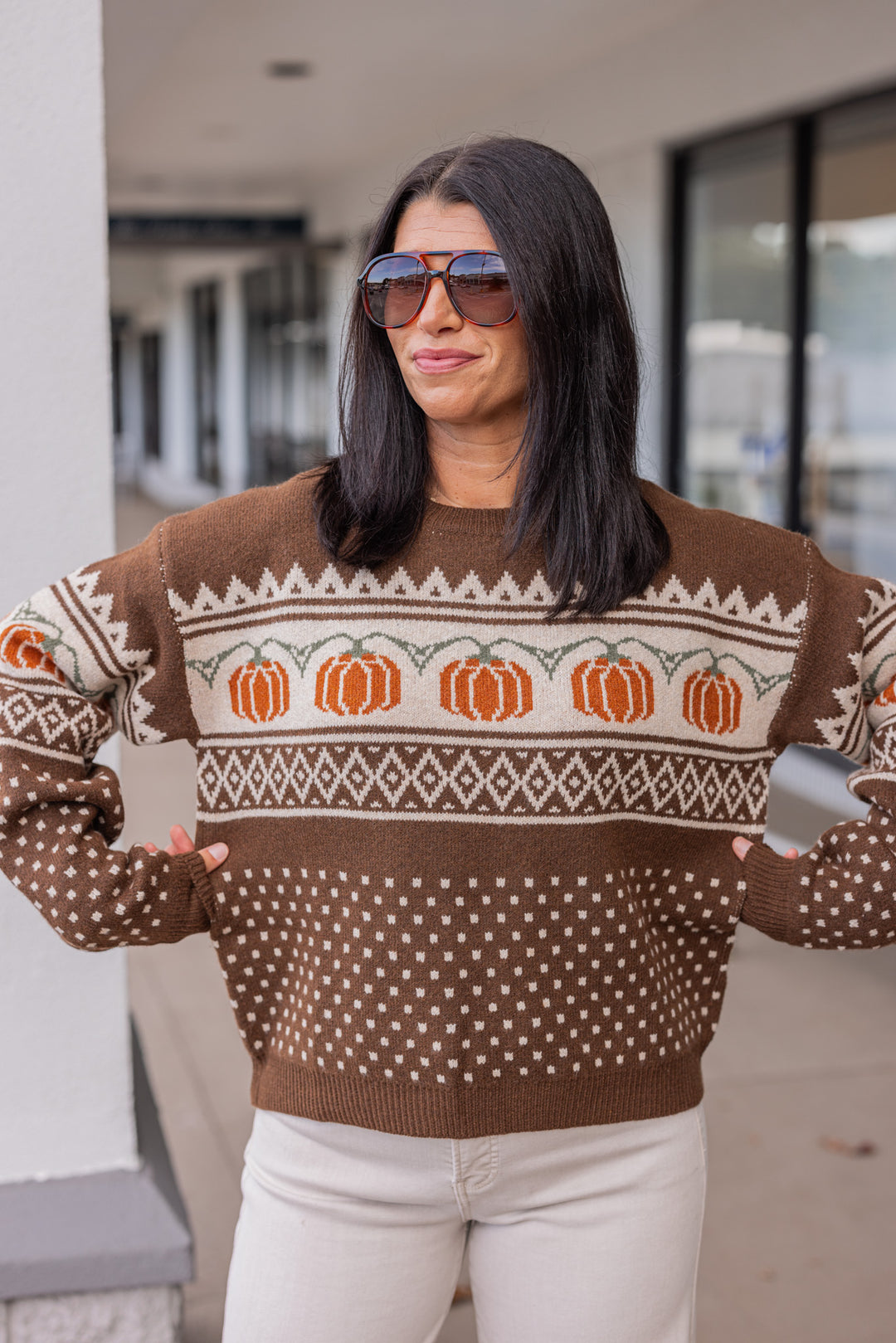 Women's chocolate brown and taupe sweater with orange pumpkin print by Entro showing true to size fit