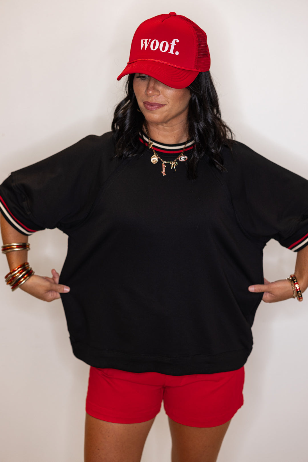 Women's black french terry knit top with cream and red striped trim by Entro showing relaxed silouhette