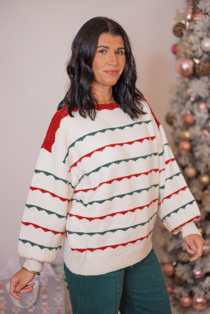 Women's ivory sweater with green and red scalloped stripes by Peach Love California showing slight side view
