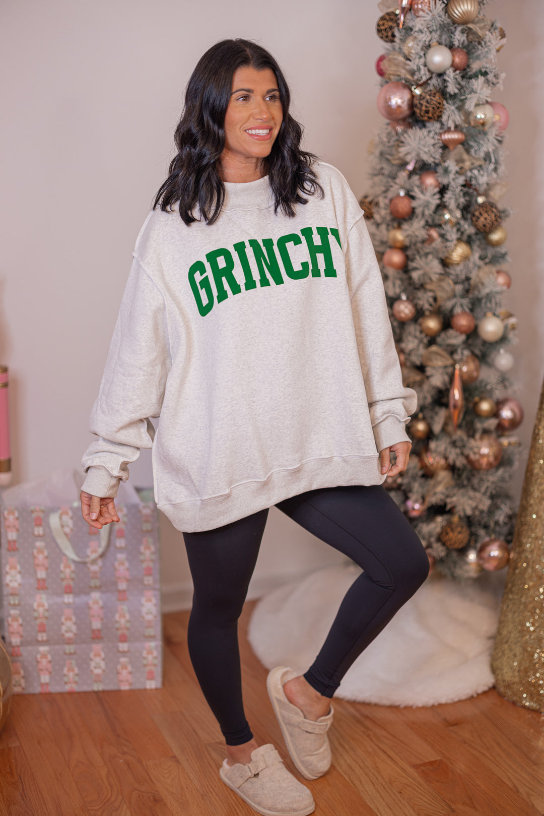 Women's reversible sweatshirt with "Grinchy" on grey or "Naughty" on white by BucketList showing angled view