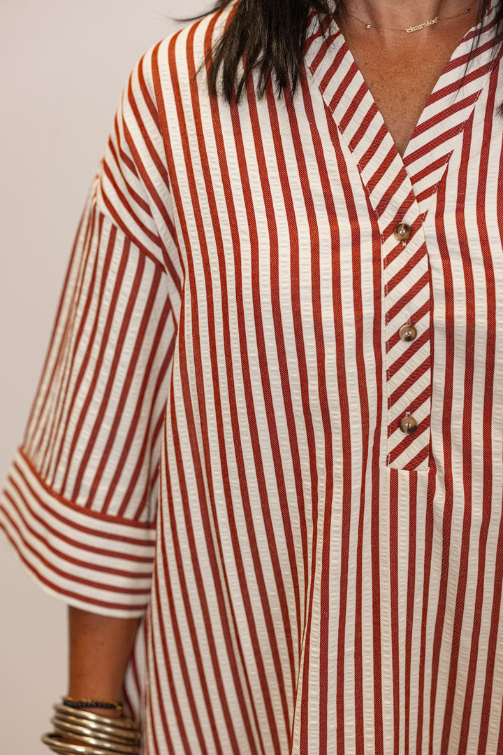 Close up of Woman's rust and ivory striped with button detail