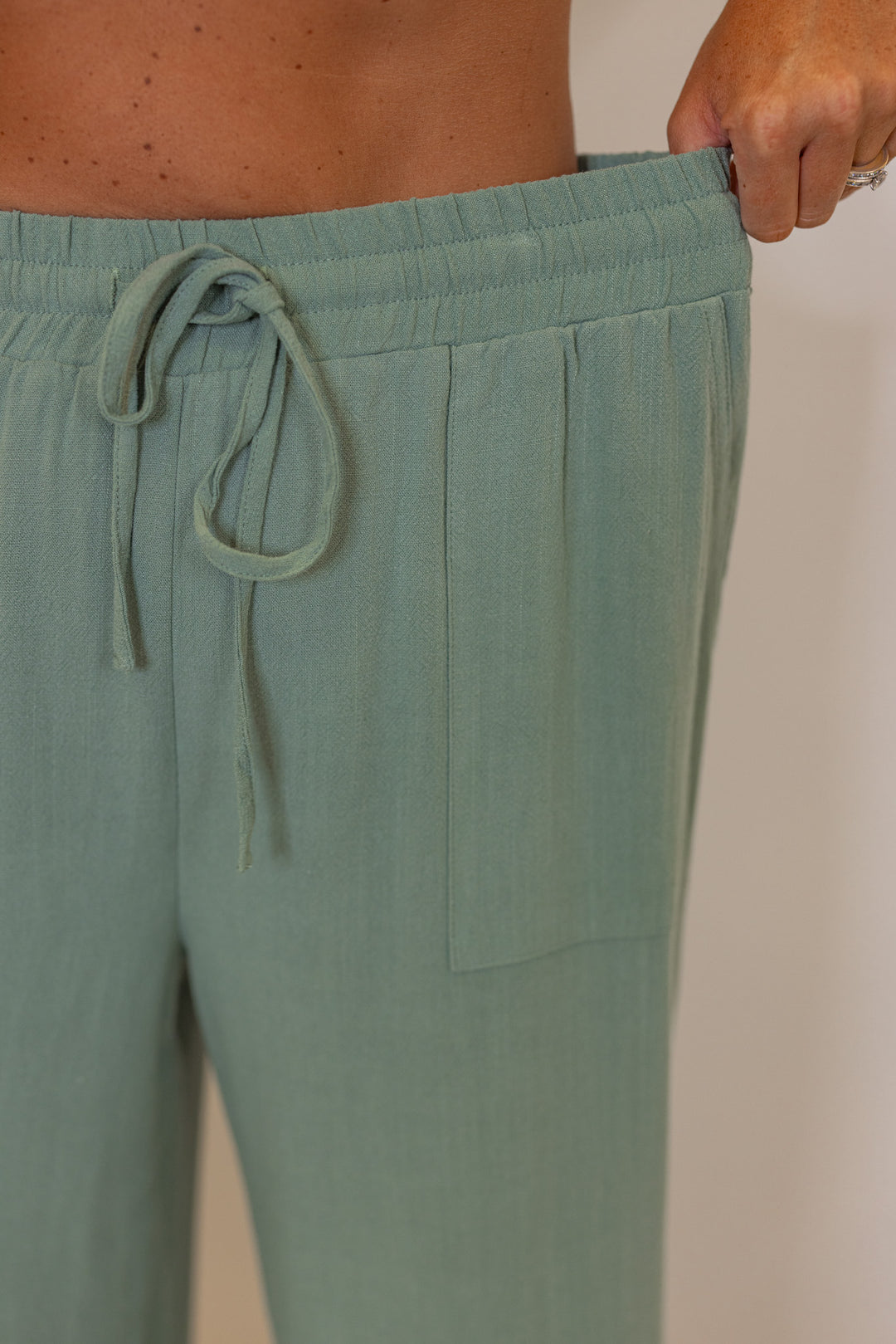 Women's sage green linen bow tie top and elastic waist wide leg pants set by Jodifl showing elastic waistband