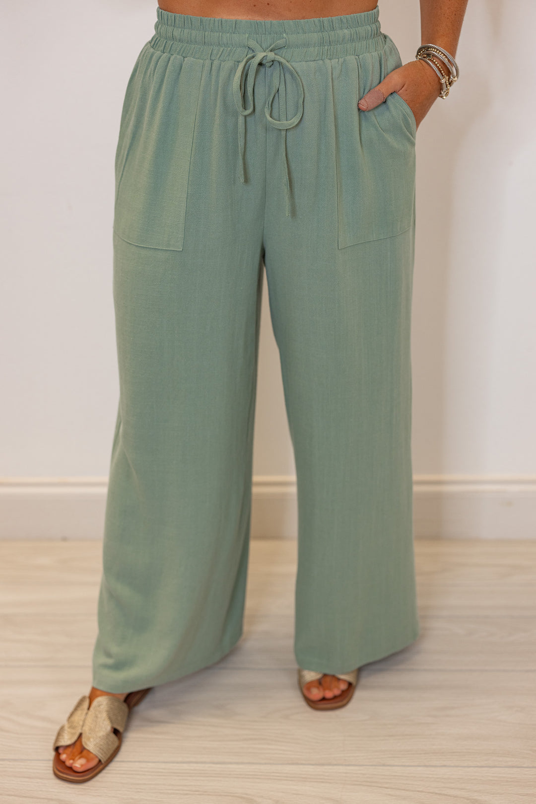 Women's sage green linen bow tie top and elastic waist wide leg pants set by Jodifl showing up close front view of pants
