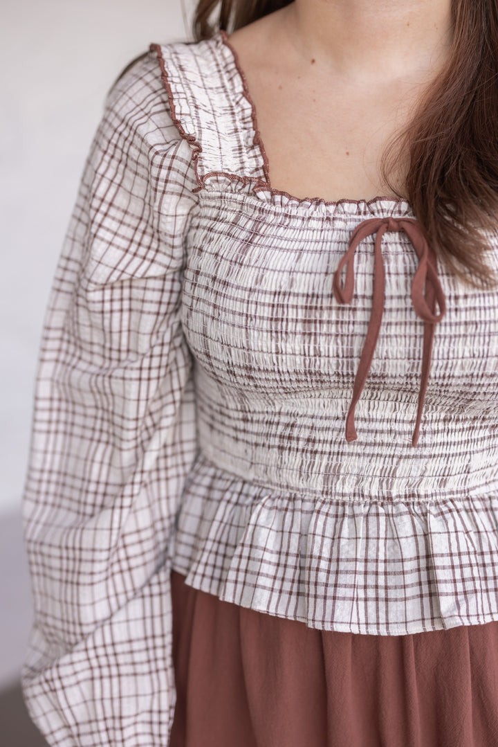 Women's ruffle detailed midi dress with smocked plaid top and solid brown skirt by In February showing fitted bodice
