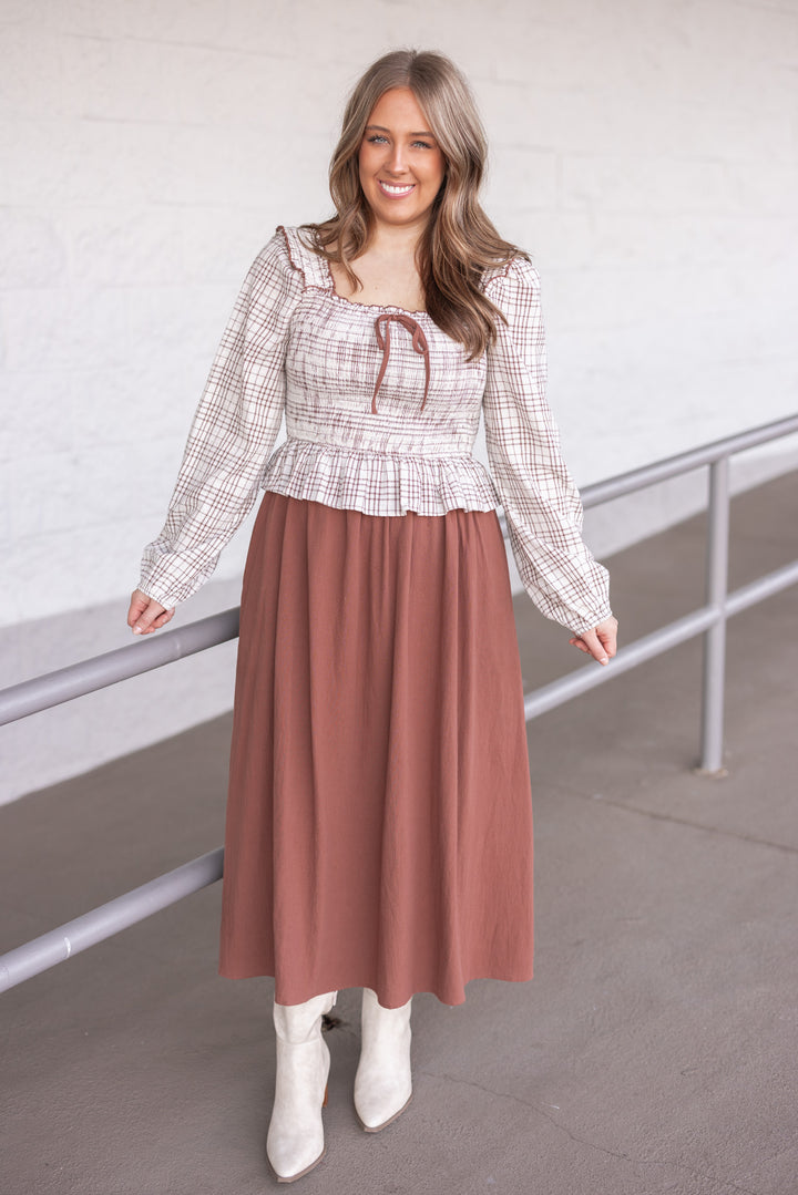 Women's ruffle detailed midi dress with smocked plaid top and solid brown skirt by In February showing full front view