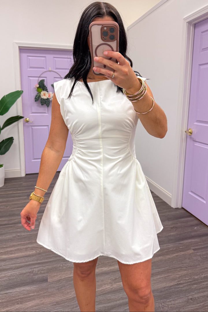 solid white sleeveless mini dress with cinched side panels at waist and crew neckline