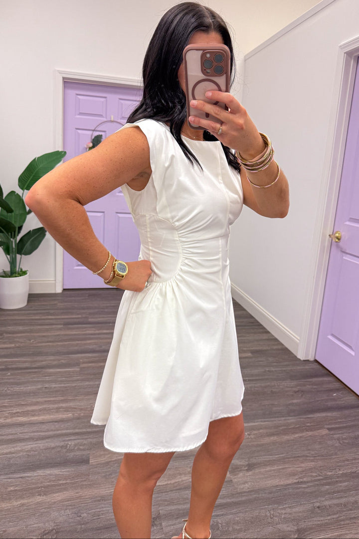 solid white sleeveless short dress with cinched side panels at waist