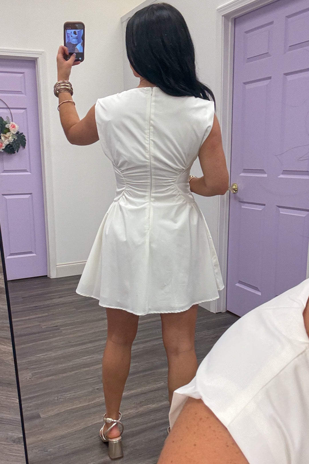 solid white sleeveless mini dress with cinched side panels at waist and back zipper closure