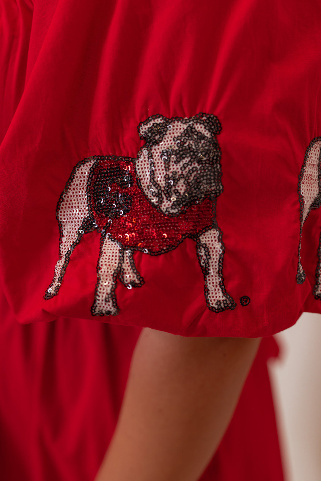 Women's red puff sleeve dress with sequin UGA Bulldogs by Stewart Simmons showing up close view of bulldog details
