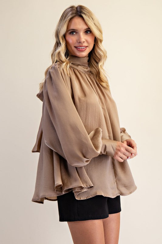 Women's taupe shimmering satin mock neck top with bow tie back showing side view