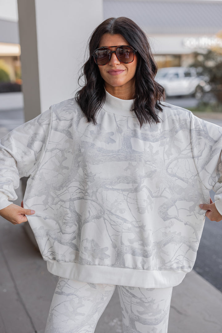 Women's grey snow camo sweatshirt by BucketList showing oversized fit