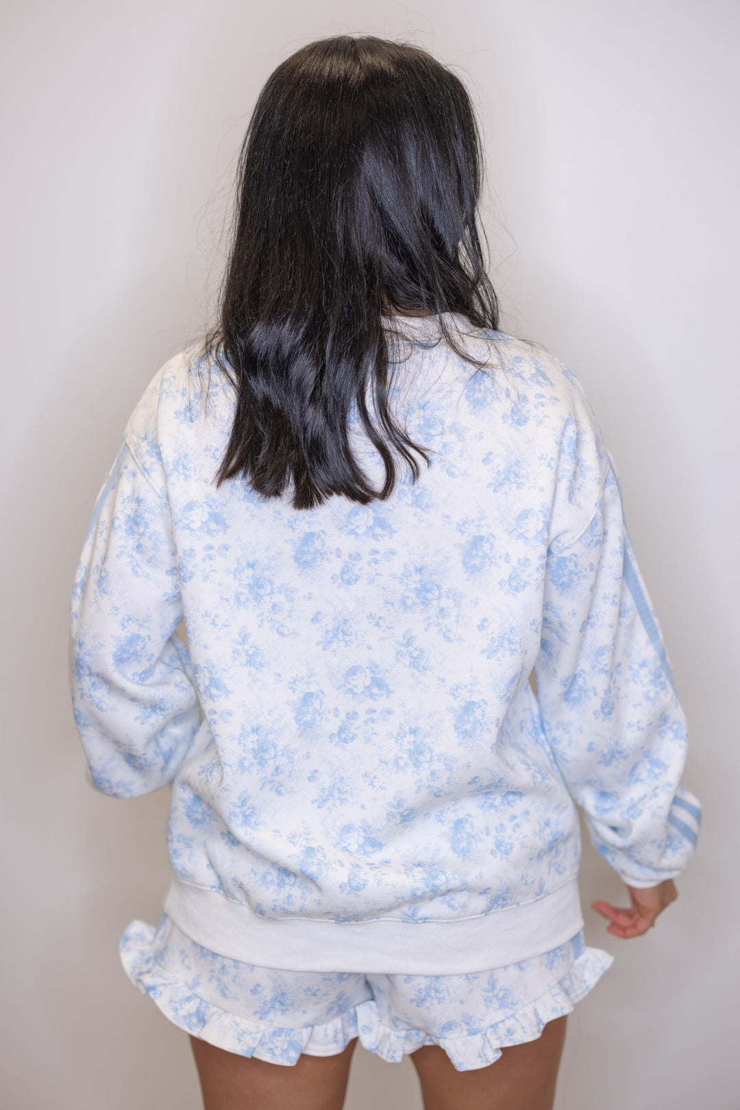 Women's cream french terry knit pullover sweatshirt with light blue floral print showing up close back view