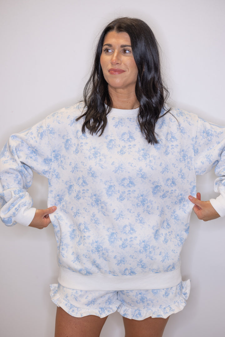 Women's cream french terry knit pullover sweatshirt with light blue floral print showing true to size fit