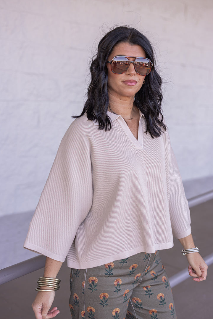 Women's light beige ribbed knit top with a collar by Entro showing slight side view