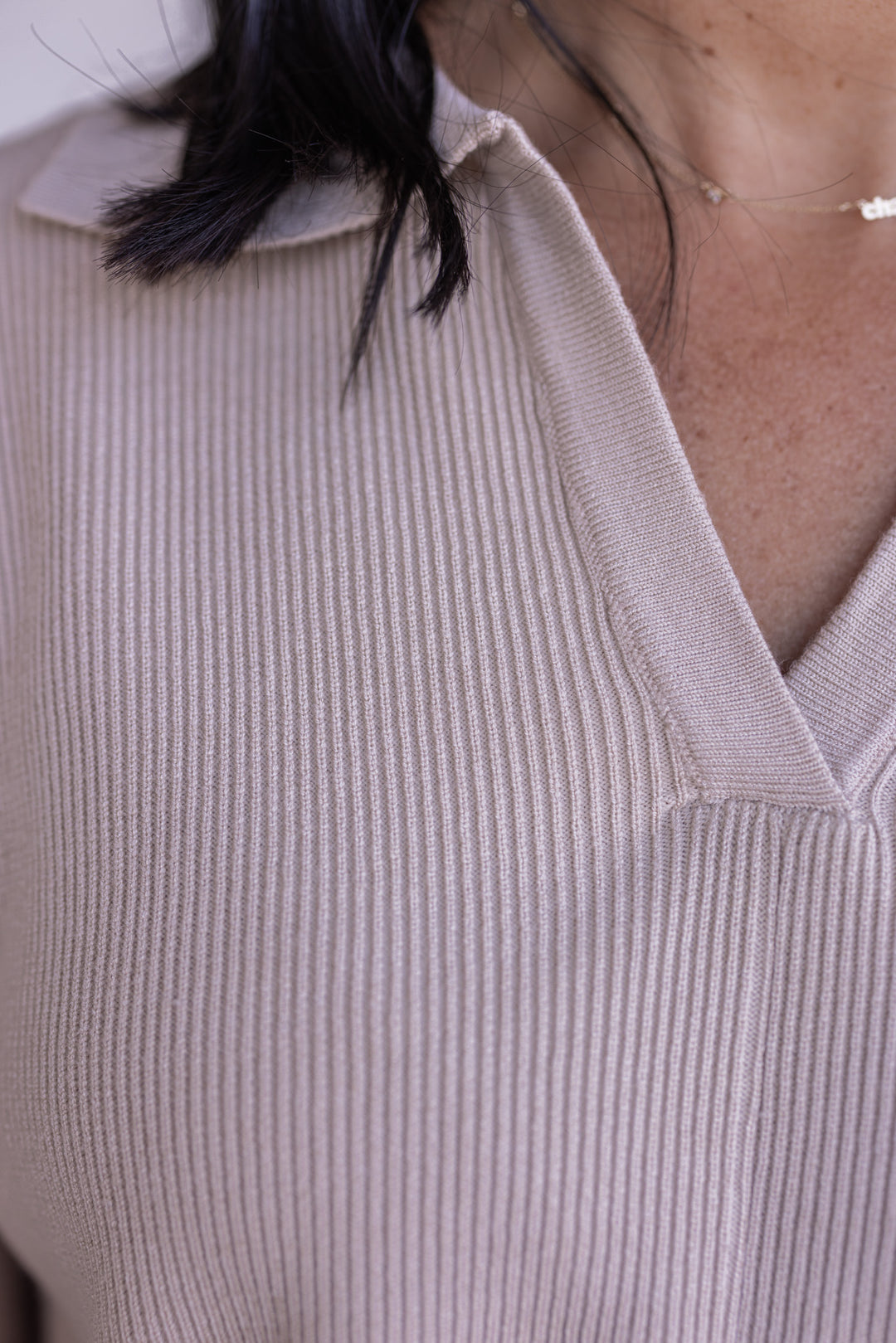 Women's light beige ribbed knit top with a collar by Entro showing ribbed knit fabric