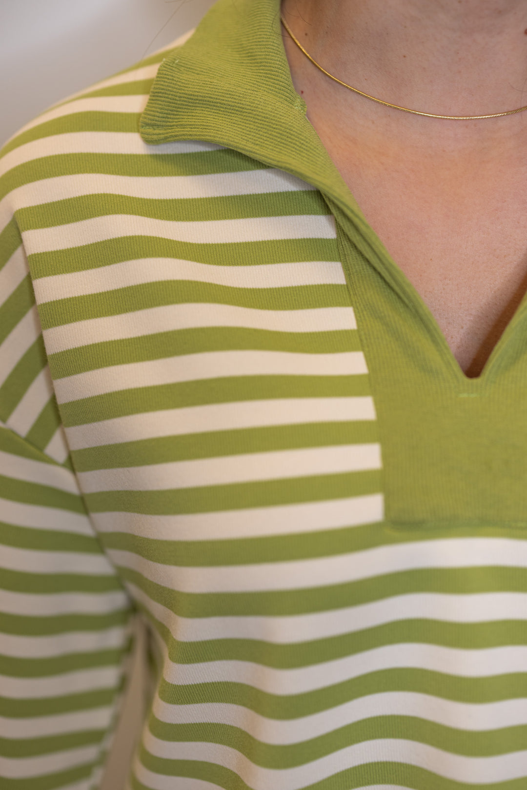 Women's ribbed knit top in matcha green and cream stripes by Entro showing v neckline with collar