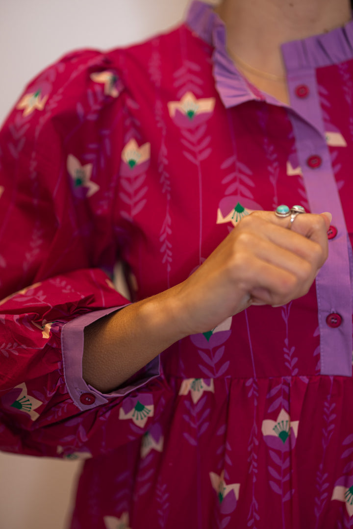 Women's magenta pink floral print tiered midi dress with button front bodice by Jodifl showing lavender trim details