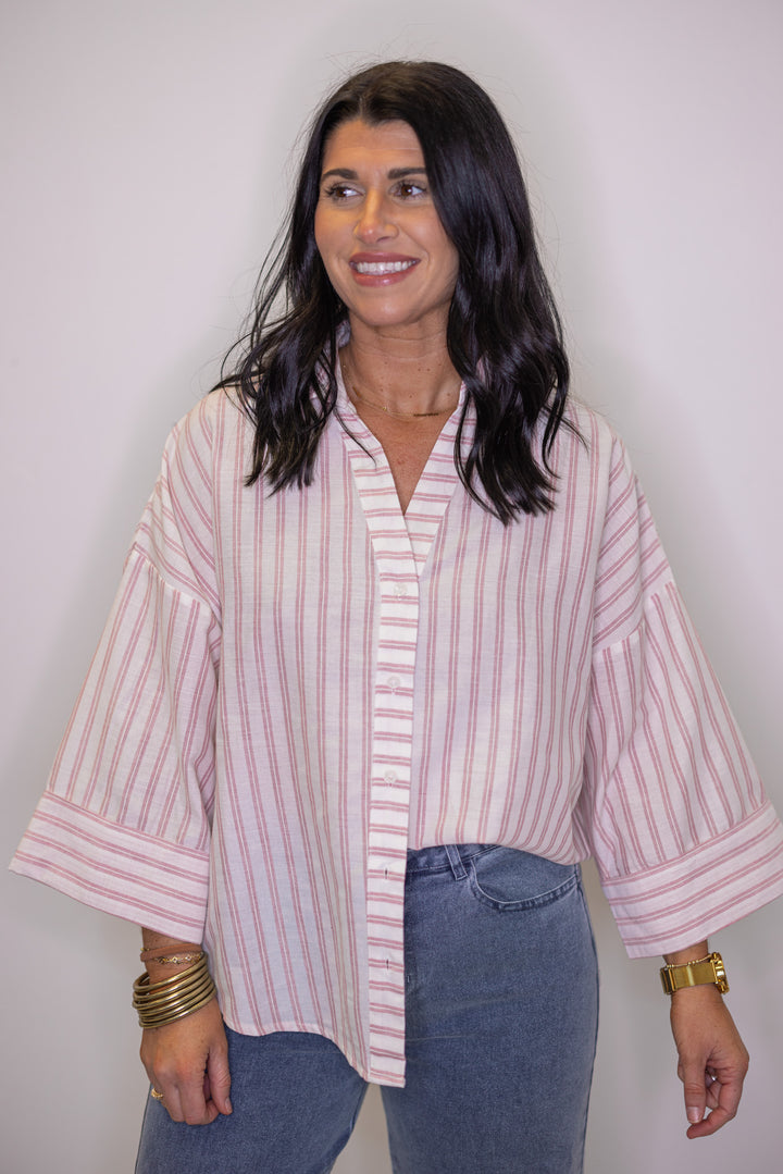 Women's pink and cream striped top showing button front closures