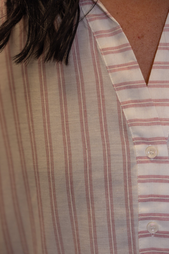 Women's pink and cream striped button down top showing trendy striped pattern
