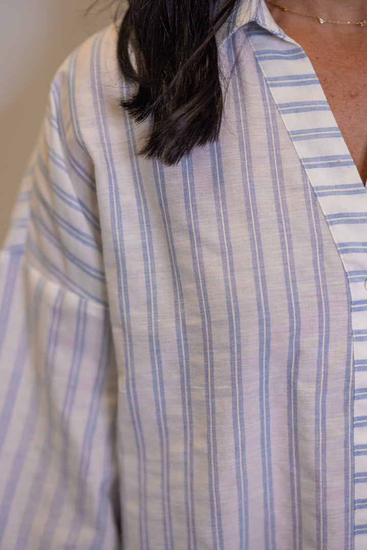 Women's light blue and cream button down top showing trendy striped pattern