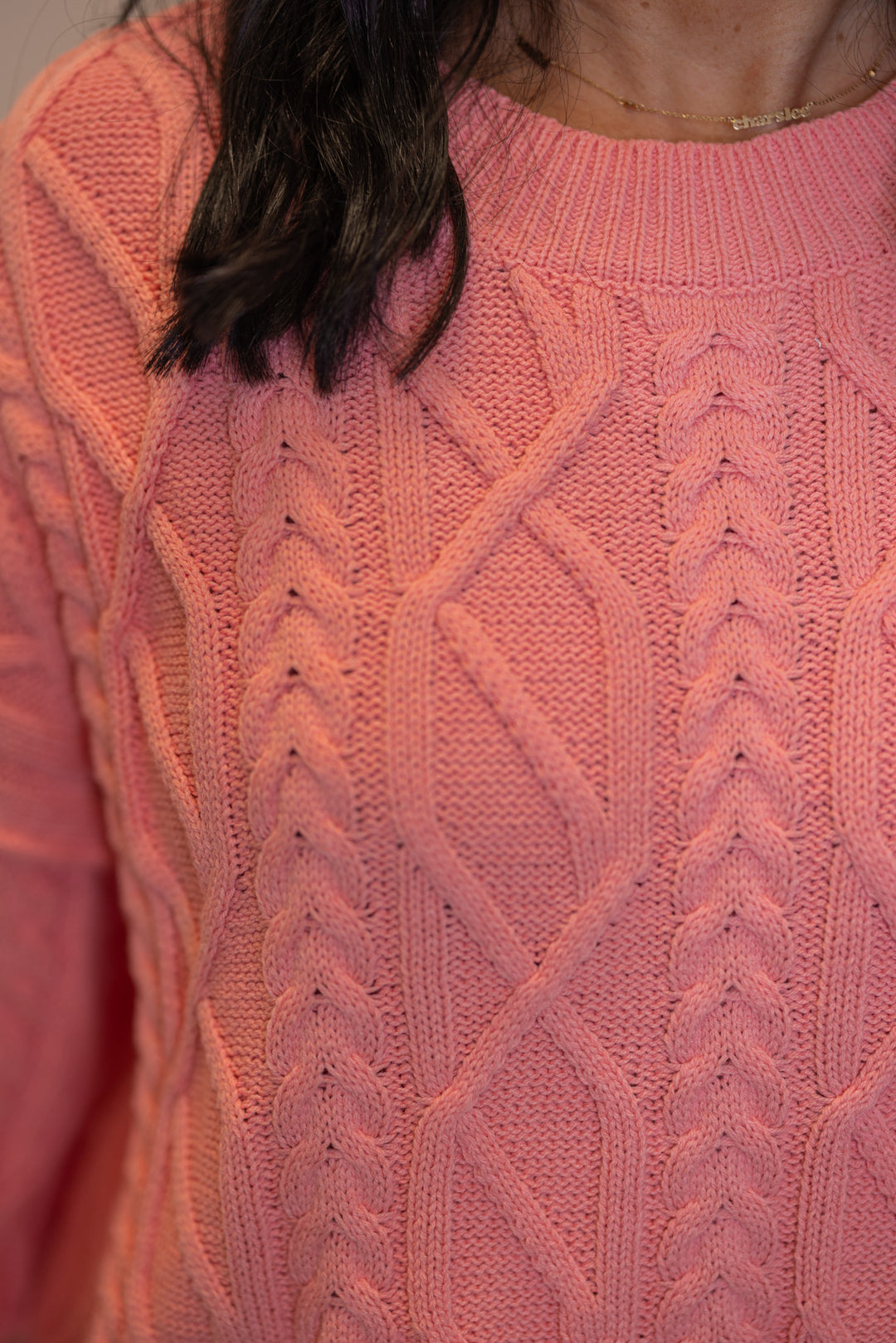 Women's pink cropped sweater by Entro showing close look at cable knit fabric