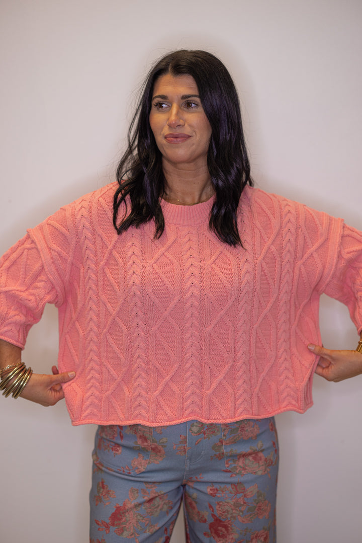 Women's coral pink cable knit sweater by Entro showing cropped length