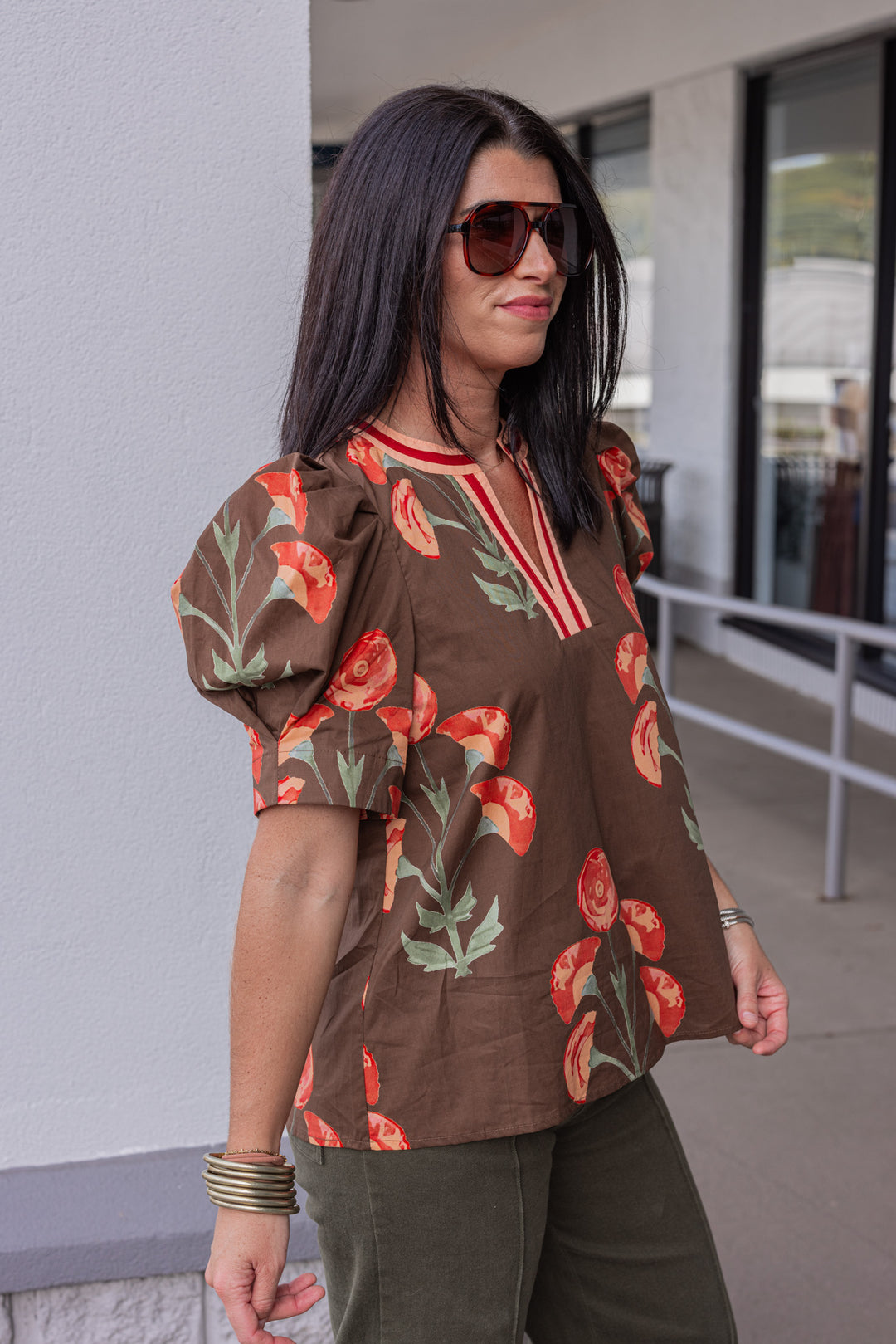 Women's brown poplin top with burgundy, peach and olive green floral print by Entro showing slight side view