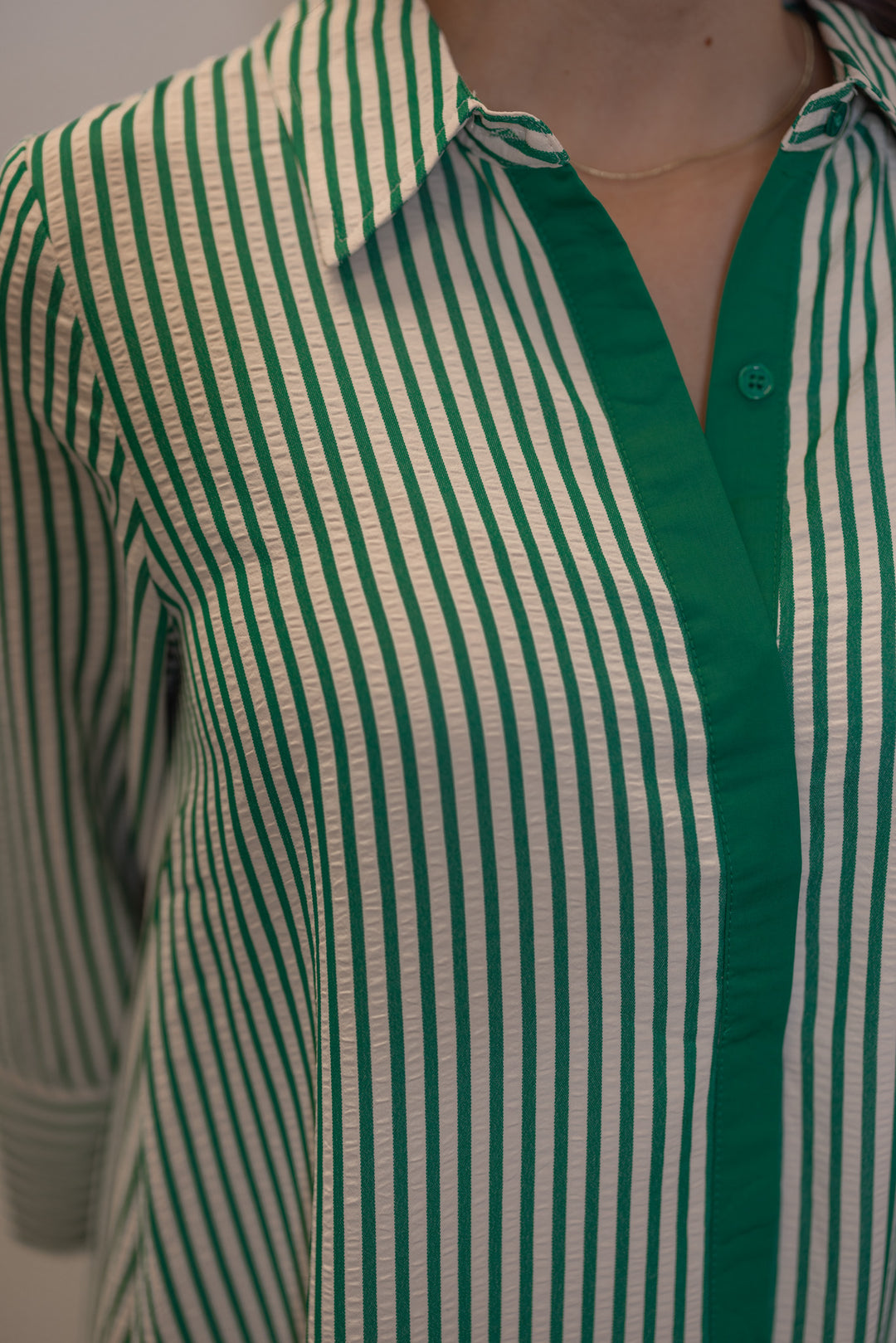 Women's striped green maxi dress by Entro showing hidden button detail