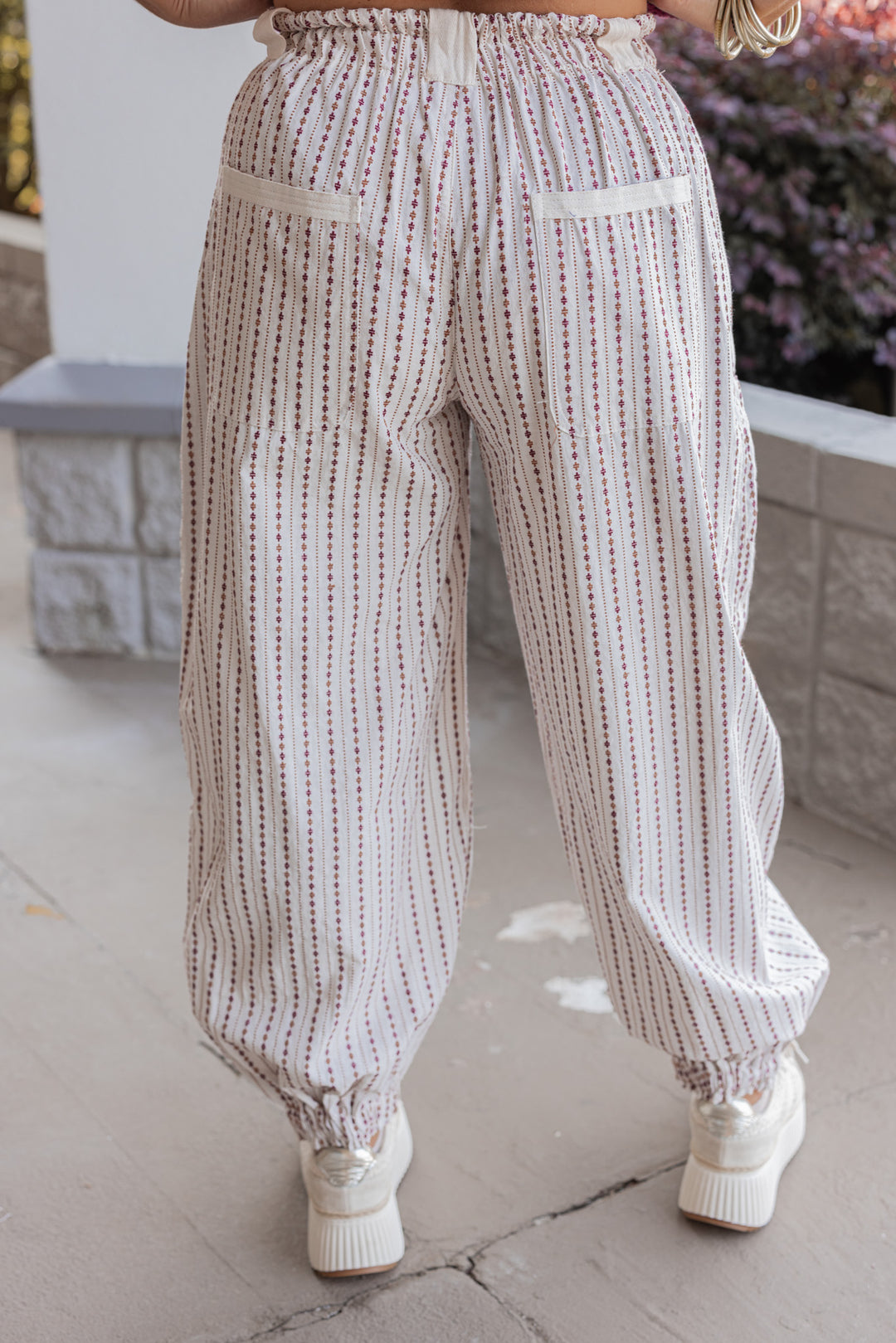 Women's oatmeal cargo jogger pants with redish brown and caramel print stripes by ee:some showing up close back view