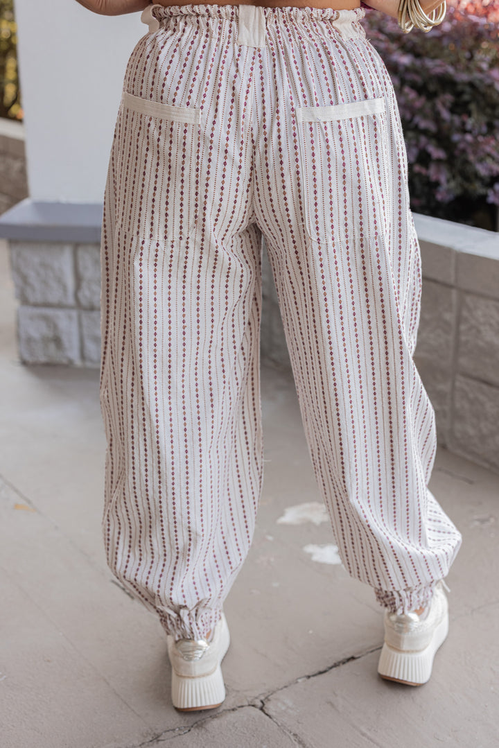 Women's oatmeal cargo jogger pants with redish brown and caramel print stripes by ee:some showing up close back view