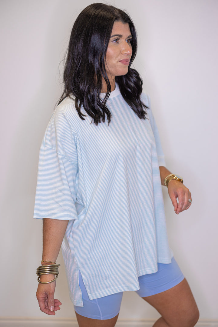 Womens light blue and white striped knit oversized top by Wishlist showing side slits in bottom hem