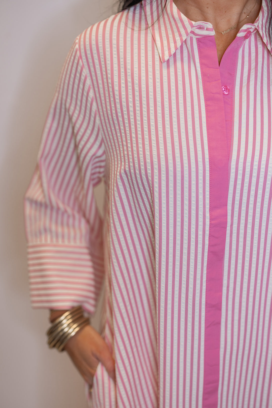 Women's striped light pink maxi dress by Entro showing hidden button details and side pockets