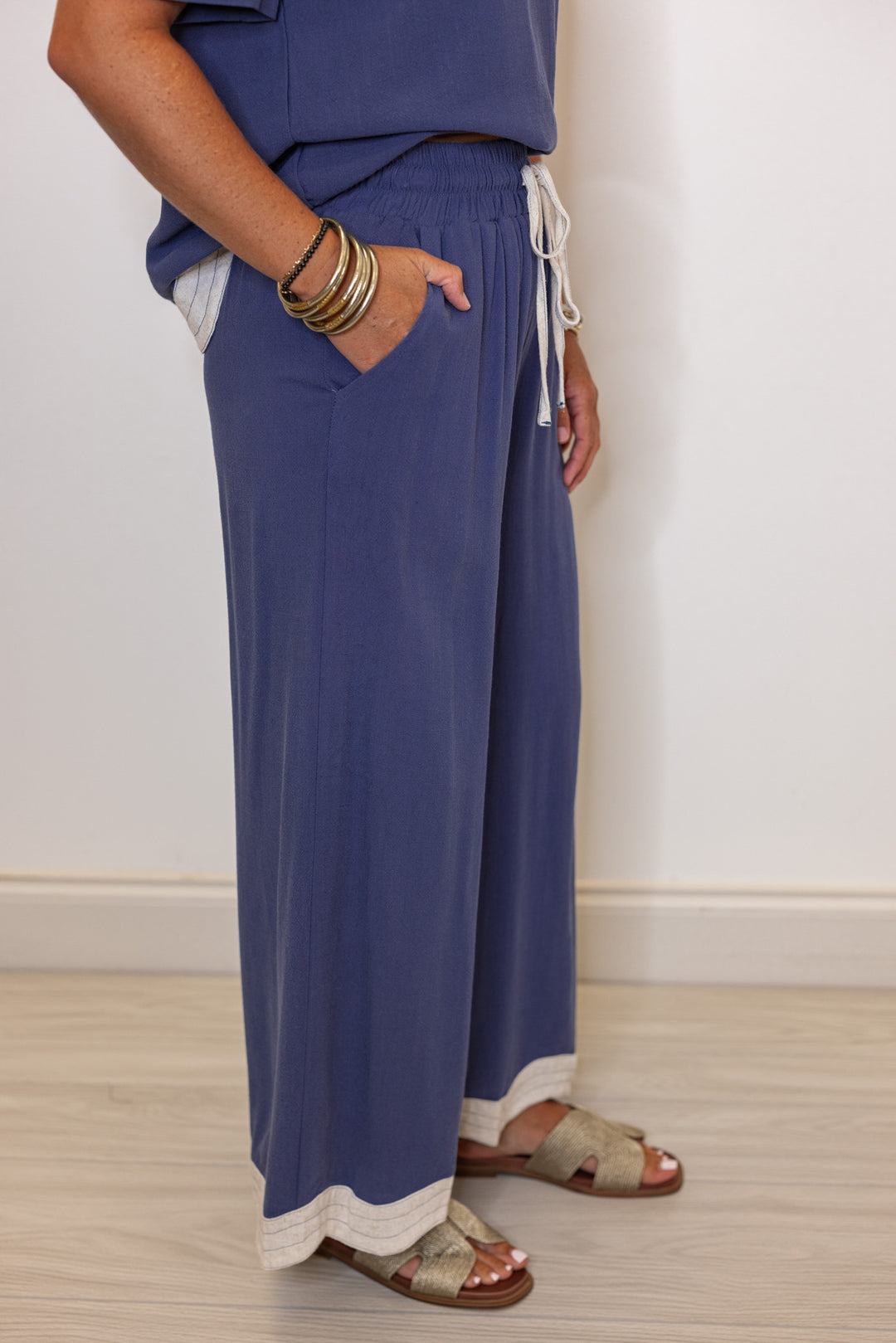 Women's linen wide leg pants in medium blue color with oatmeal scalloped hem by Umgee showing side view