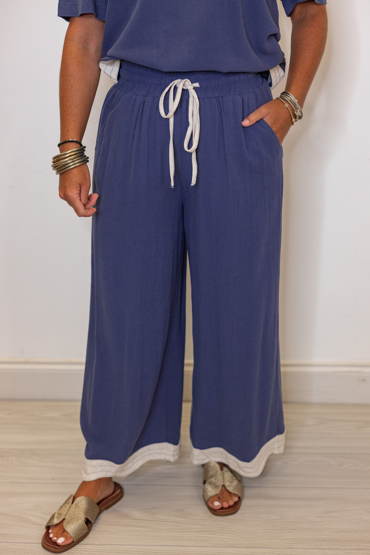 Women's linen wide leg pants in medium blue color with oatmeal scalloped hem by Umgee showing up close view