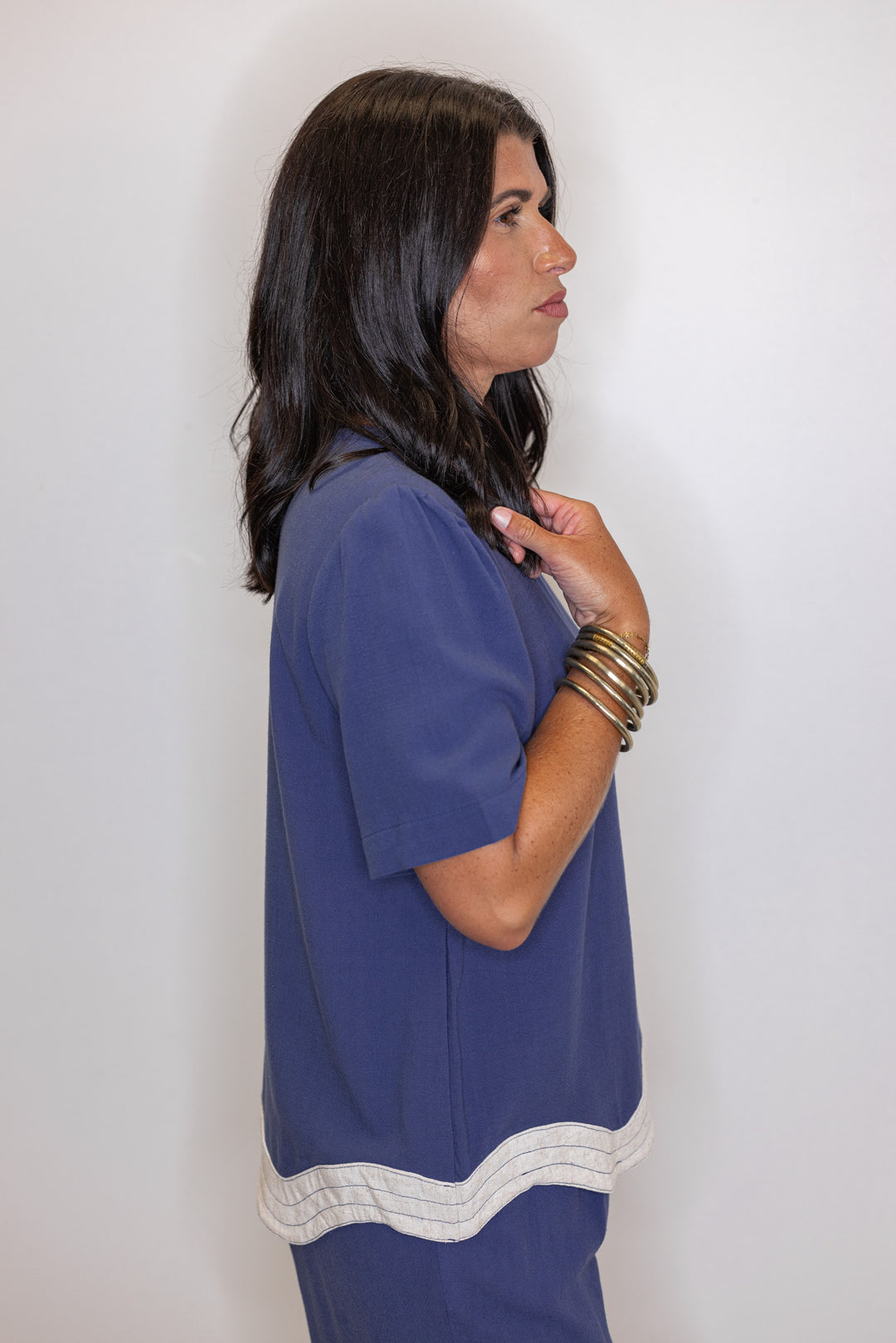 Women's linen top in medium blue color with oatmeal scalloped bottom hem by Umgee showing side view