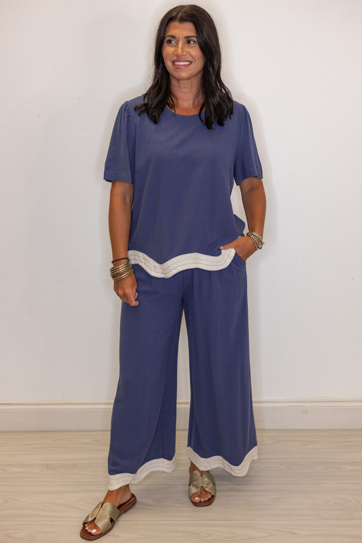 Women's linen wide leg pants in medium blue color with oatmeal scalloped hem by Umgee