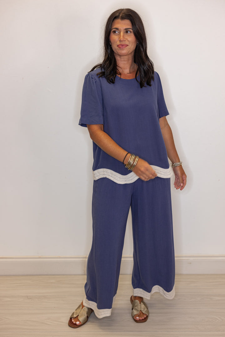 Women's linen wide leg pants in medium blue color with oatmeal scalloped hem by Umgee showing relaxed fit