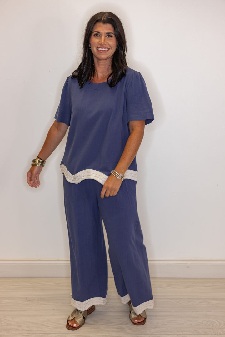 Women's linen wide leg pants in medium blue color with oatmeal scalloped hem by Umgee shown with matching top