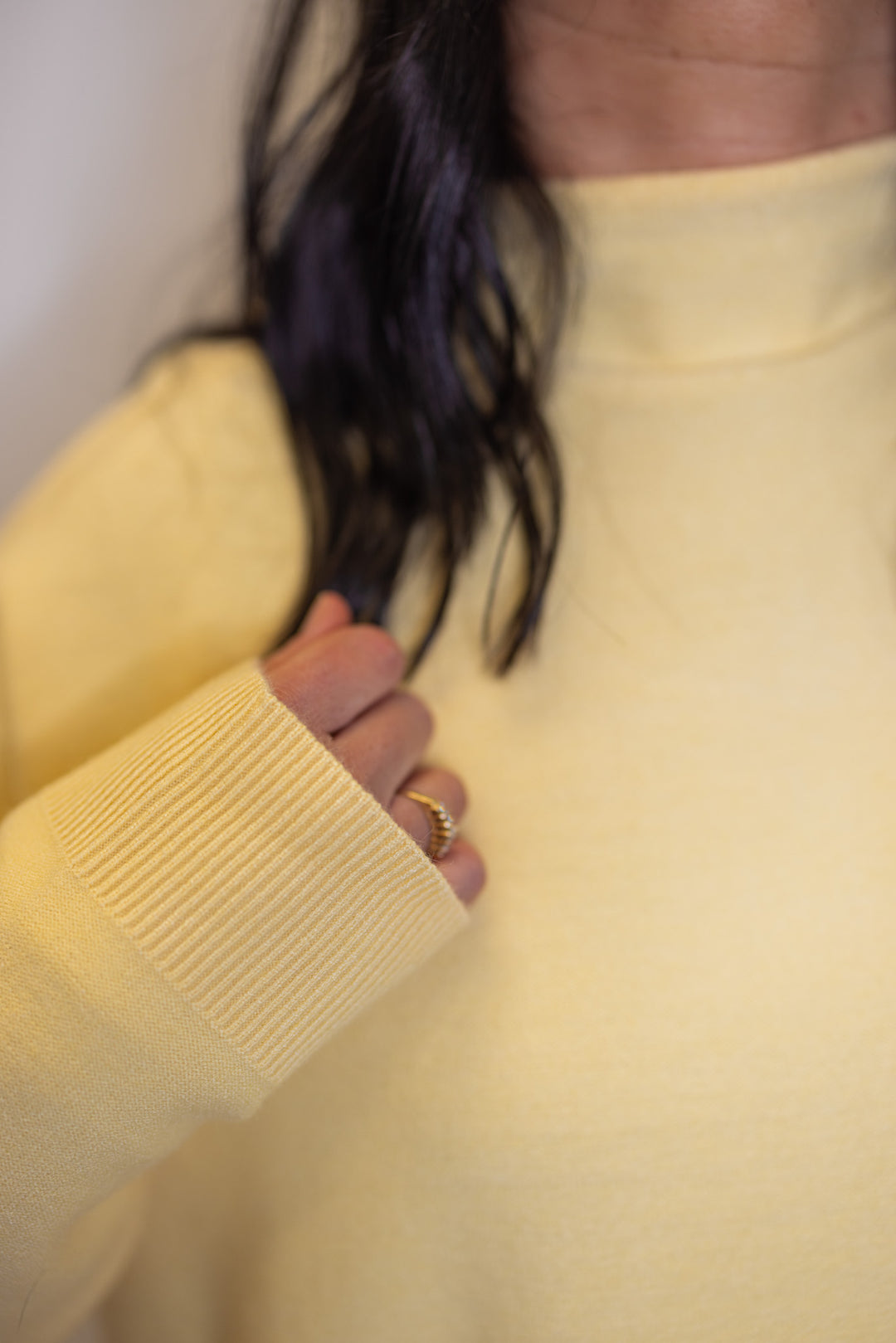 Women's butter yellow knit mock neck top showing ribbed details on sleeve